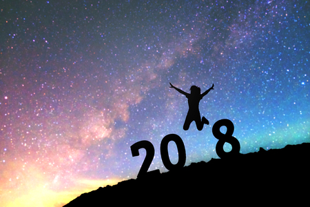 Silhouette young woman Happy for 2018 new year background on  the Milky Way galaxy pointing on a bright star. dark sky tone . Vintage grain tone.の写真素材