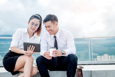 Asian Business couple meeting Using digital tablet outdoor standing in outdoor officeの写真素材