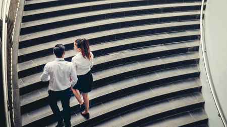 Businessman and Business woman go up the stairs Success conceptの写真素材