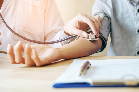 Doctor Measuring arterial blood pressure woman patient on right arm Health care in hospitalの写真素材