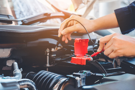 Hands check battery car mechanic working in auto repair serviceの写真素材