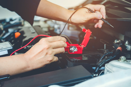 Hands check battery car mechanic working in auto repair serviceの写真素材