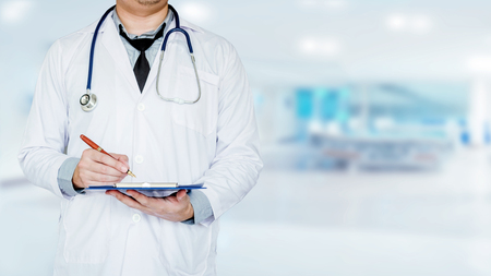 Doctor holding clipboard and stethoscope on background of Hospital wardの写真素材