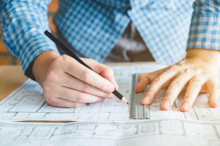 Architect or engineer working in office on blueprint. Architects workplaceの写真素材
