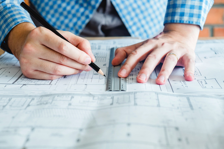 Architect or engineer working in office on blueprint. Architects workplaceの写真素材