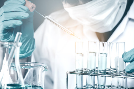 Scientist dropping chemical liquid to flask in lab Glass laboratory chemical test,Laboratory research conceptの写真素材