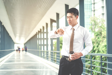 Businessman looking at watch he looks on the timeの写真素材