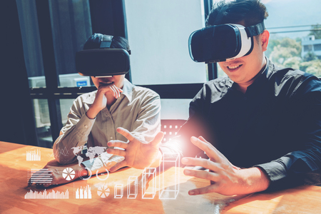 Business team meeting using Virtual Reality simulator headset and developing a new projectの写真素材