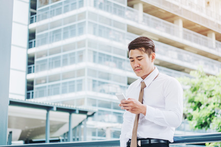 Businessman using phone and drinking a coffee and looking view and thinking successの写真素材