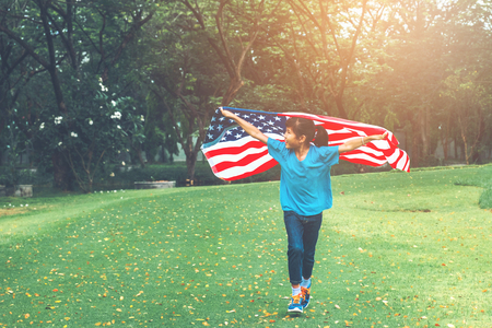 Happy kid little child running with American flag USA celebrate 4th of Julyの写真素材