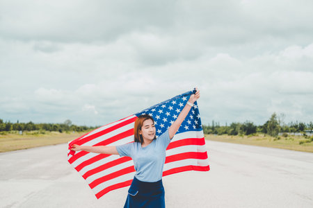 Happy woman standing with American flag Patriotic holiday.USA celebrate 4th of July