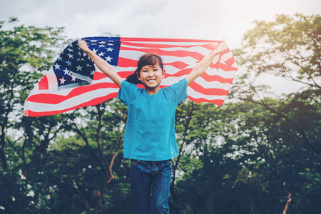 Happy kid little child running with American flag USA celebrate 4th of Julyの写真素材