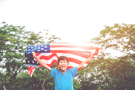 Happy kid little child running with American flag USA celebrate 4th of Julyの写真素材