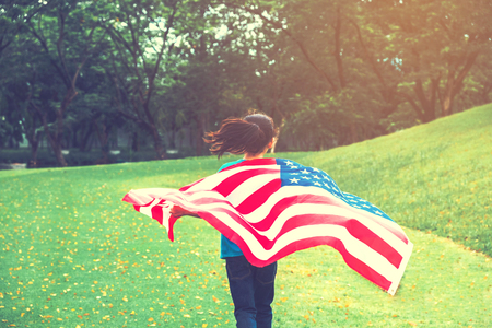 Happy kid little child running with American flag USA celebrate 4th of Julyの写真素材