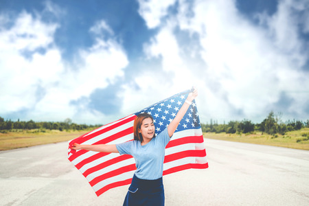 Happy woman with American flag USA celebrate 4th of Julyの写真素材
