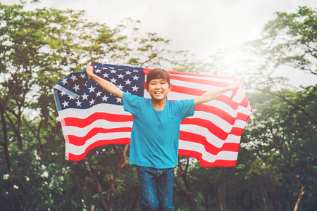 Happy kid little child running with American flag USA celebrate 4th of Julyの写真素材