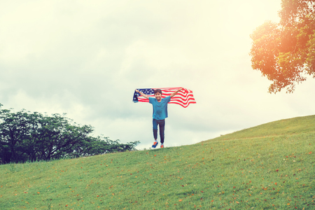 Happy kid little child running with American flag USA celebrate 4th of Julyの写真素材