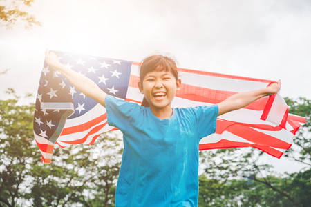 Happy kid little child running with American flag USA celebrate 4th of Julyの写真素材