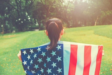 Happy kid little child running with American flag USA celebrate 4th of Julyの写真素材