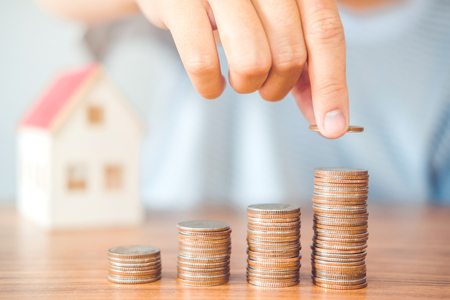 Saving money concept man hand putting coin stack finance for budgetの写真素材