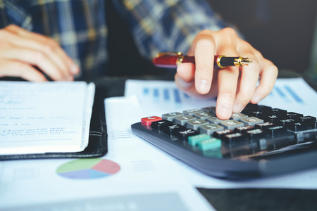 Businessman's hands with calculator at the office and Financial data analyzing countingの写真素材