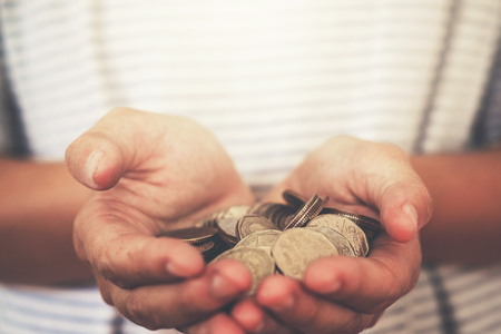 Saving money concept man hand putting coinの写真素材