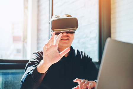 Business man using Virtual Reality simulator headset and developing a new projectの写真素材