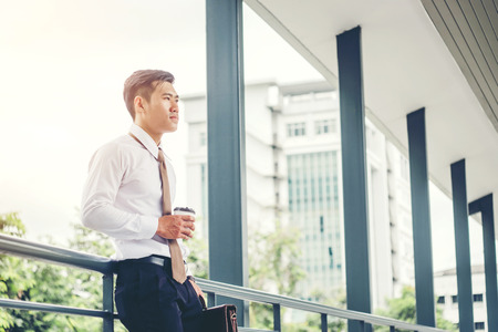 Businessman drinking a coffee and looking view and thinking successの写真素材