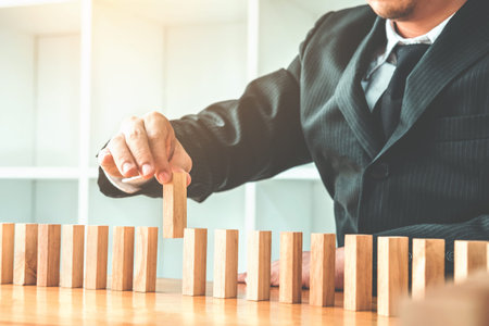 Businessman plan and strategy in business Domino Effect Leadership Management Solution concept