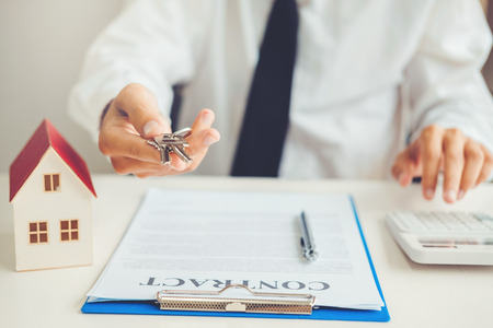 Sale agent giving house keys to customer and sign agreement contract, Insurance Home conceptの写真素材