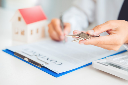 Sale agent giving house keys to customer and sign agreement contract, Insurance Home conceptの写真素材