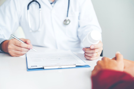 Doctor or physician recommend pills medical prescription to male Patientの写真素材