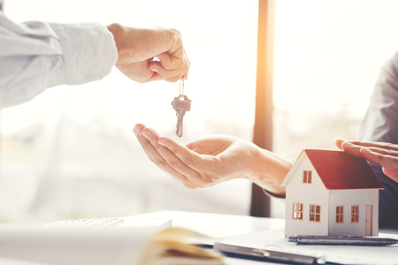 Sale agent giving house keys to customer and sign agreement contract, Insurance Home conceptの写真素材