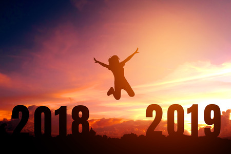 Silhouette young woman jumping to 2019 new yearの写真素材
