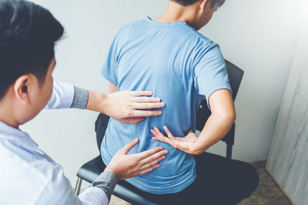 Doctor consulting with patient Back problems Physical therapy conceptの写真素材