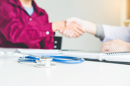Confident Doctor shaking hands with patients talk in the hospitalの写真素材