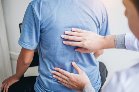 Doctor consulting with patient Back problems Physical therapy conceptの写真素材
