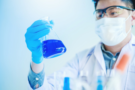 Scientist with equipment holding tools during scientific experiment science conceptの写真素材