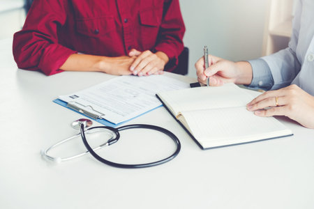 Doctors and patients sit and talk. At the table near the window in the hospital.の写真素材