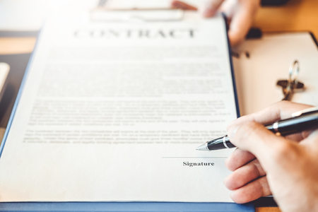 Business people negotiating a contract handshake between two colleaguesの写真素材