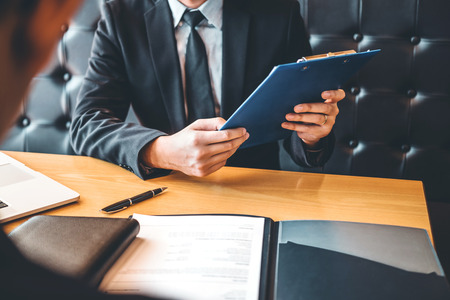 Senior manager reading a resume during a job interview employee young man meeting Applicant and recruitment conceptの写真素材
