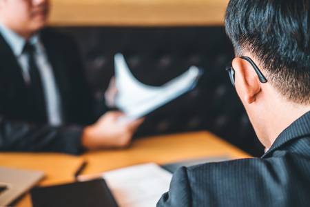 Senior manager reading a resume during a job interview employee young man meeting Applicant and recruitment conceptの写真素材