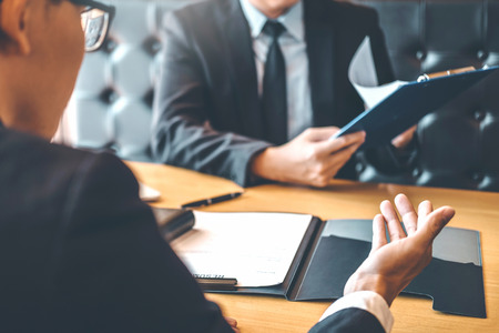 Senior manager reading a resume during a job interview employee young man meeting Applicant and recruitment conceptの写真素材