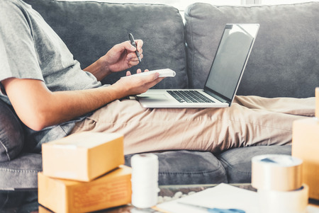SME freelance man working with packaging startup entrepreneur small business owner at home,Online business seller packaging and delivery conceptの写真素材