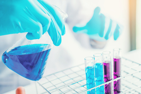 Scientist with equipment holding tools during scientific experiment science conceptの写真素材