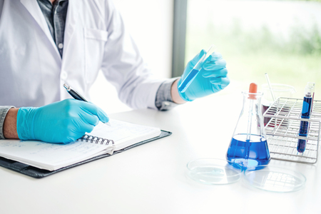 Scientist with equipment holding tools during scientific experiment science conceptの写真素材