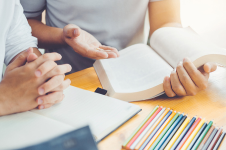High school or college students studying and reading together in libraryの写真素材