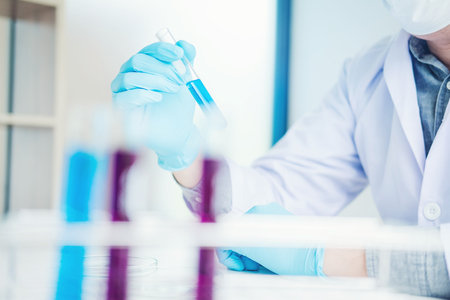 Scientist with equipment holding tools during scientific experiment science conceptの写真素材