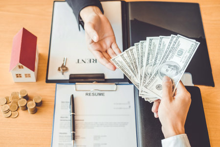 Customer giving Money Dollar bill  to Sale agent and sign agreement contract, Insurance Home concept