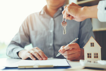 Sale agent giving Key house to customer and sign agreement contract, Insurance Home conceptの写真素材
